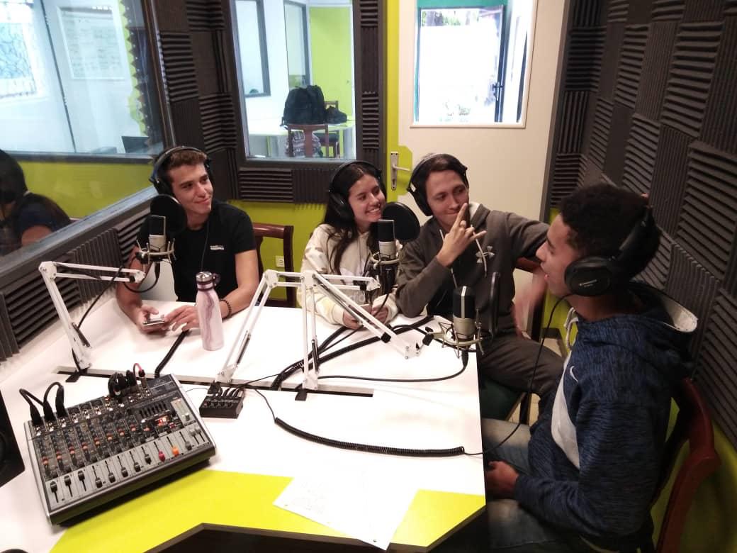 Oriana en estudio de radio junto a un equipo de trabajo